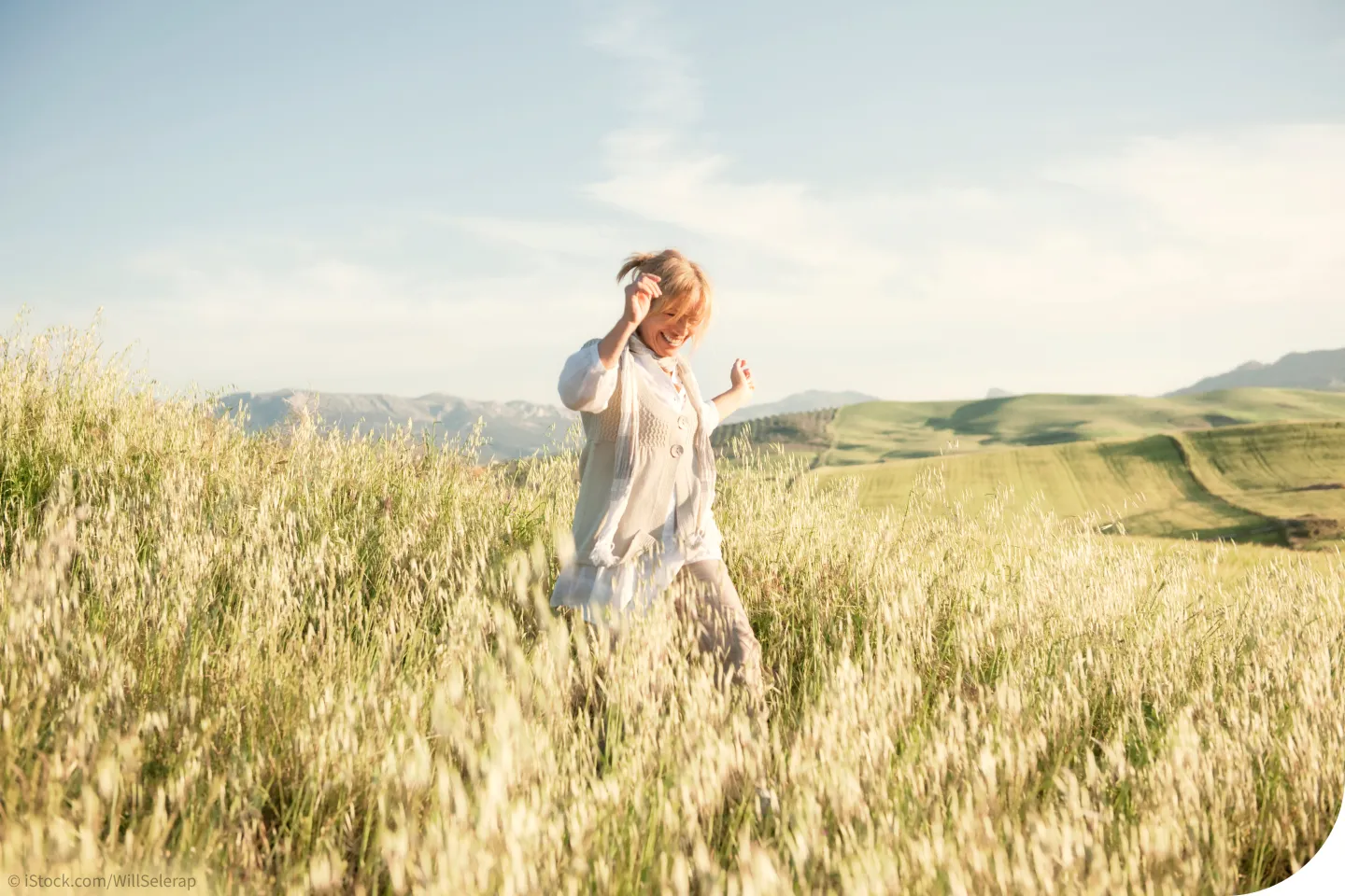 fit im Alter: Eine ältere Frau spaziert durch ein Kornfeld. Blogbild vom Seniorenmagazin LebenPlus